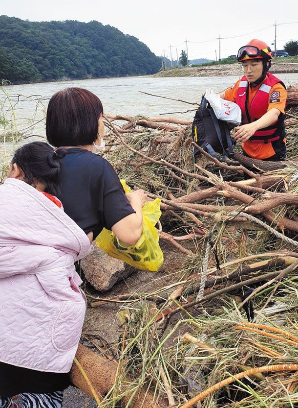 10일 최용수 소방관이 경기도 양평군의 한 마을에서 주민을 도와 폭우로 인해 나무와 쓰레기 등이 쌓인 다리를 건너고 있다. /독자 제공