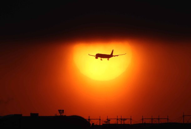 떠오르는 태양으로 붉게 물든 하늘을 가로지르며 여객기가 인천국제공항 상공을 비행하고 있다. 김상선 기자