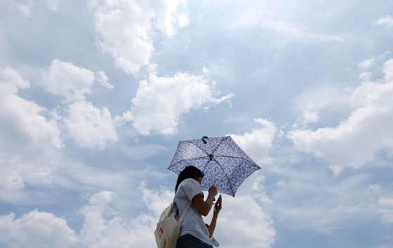 30도 안팎의 낮더위가 이어지고 있는 8일 서울 광화문광장에서 파란하늘 아래 양산을 쓴 시민들이 연휴를 만끽하고 있다. 뉴스1