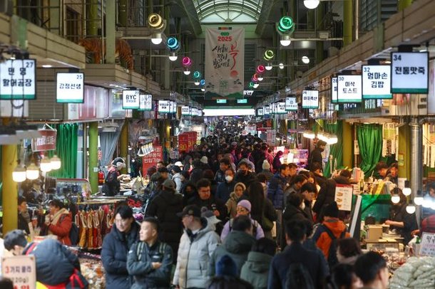 설 연휴 이틀째인 지난 26일 시민들이 서울 시내의 한 전통시장에서 물건을 살펴보고 있다. 연합뉴스