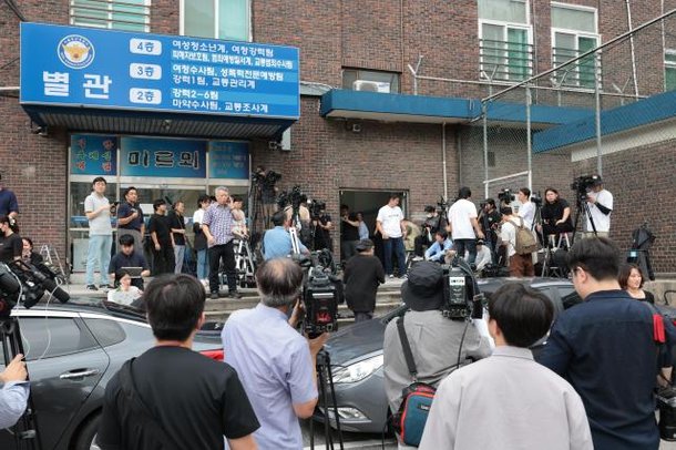 22일 오전 서울 용산경찰서 별관에서 취재진이 만취 상태로 전동스쿠터를 운전한 혐의를 받는 BTS의 슈가 경찰 출석에 대기 중인 모습 사진연합뉴스