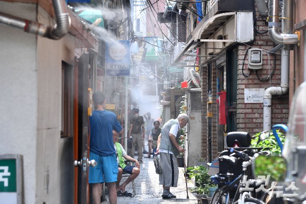 낮 최고기온이 35도까지 치솟으며 전국 대부분 지역에 폭염 경보가 발령된 31일 서울 종로구의 한 쪽방촌에서 주민들이 쿨링포그를 맞으며 더위를 식히고 있다. 류영주 기자