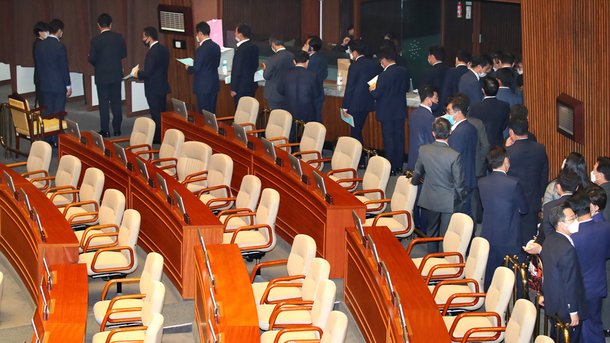 미래통합당이 원구성 협상안에 반발하면서 자당 소속 상임위원 명단을 내지 않고 본회의에 불참하자 박병석 국회의장이 상임위 강제 배정 조치에 따라 29일 오후 2시 본회의를 열고 민주당이 자당 몫으로 배정한 11개 상임·특별위원장 선출 안건을 표결에 부쳐 안건을 처리했다. 민주당 의원들이 불참한 미래통합당 좌석 뒤로 투표를 위해 줄을 서 있다.