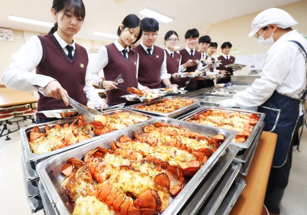 14일 오후 경기도 수원시 영통구 효원고등학교에서 학생들이 점심 급식으로 제공된 랍스터 테일 구이를 배식받고 있다. /연합뉴스