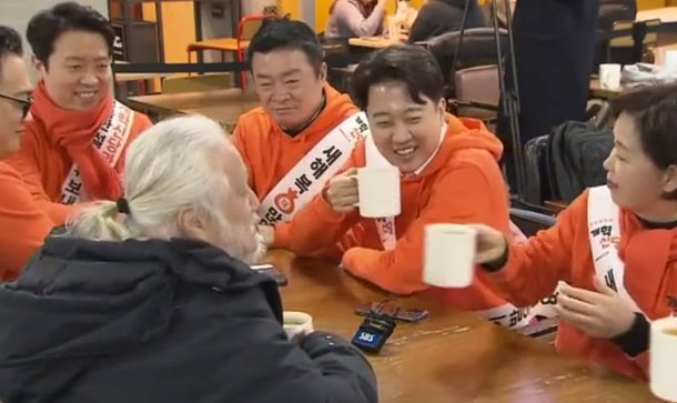 지난 8일 서울 수서역 내 한 카페에서 개혁신당 이준석 대표가 박경석 전장연 대표와 대화하고 있다. 이 대표가 커피를 마시는 동안 양향자 원내대표가 잔을 받지 못한 이들에게 커피를 전달하고 있다. /OBS 유튜브