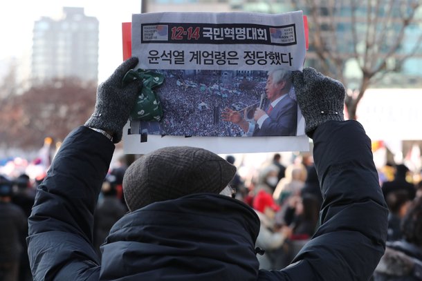 윤석열 대통령에 대한 국회 탄핵소추안 표결일인 14일 서울 세종대로 일대에서 대한민국살리기국민운동본부를 비롯한 보수단체 회원들이 ‘윤석열 계엄령은 정당했다’ 문구가 적힌 전단지를 들고 12·14 광화문 국민혁명대회에 참석하고 있다. /뉴스1