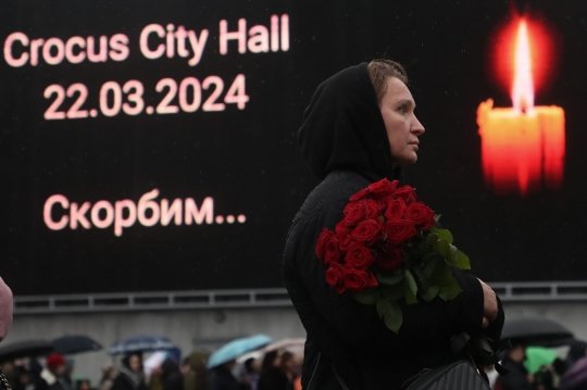 러시아 모스크바 크로커스 시티홀 공연장에서 발생한 총격 사건의 희생자들을 애도하기 위해 한 여성이 24일현지시간 공연장 앞에서 장미꽃을 들고 있다. 모스크바/EPA연합뉴스
