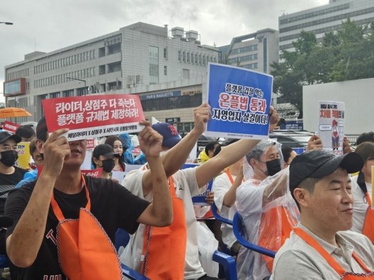 지난달 22일 서울 용산구 대통령실 앞에서 열린 ‘배달플랫폼 자율규제 규탄’ 집회 현장에서 자영업자 등 참석자들이 피켓을 들고 구호를 외치고 있다.문현호 기자 m2h@