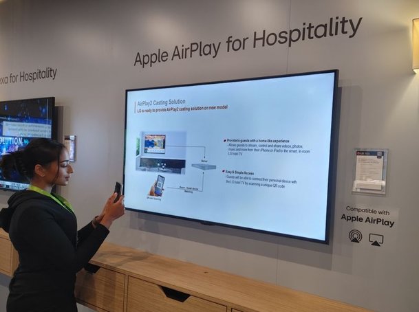 LG전자 모델이 지난해 6월 미국 토론토에서 열린 호스피털리티 산업 박람회 HiTEC 2023에서 애플의 무선 콘텐츠 공유 기술인 에어플레이Airplay 기능이 적용된 세계 최초의 호텔 TV를 체험하고 있다. LG전자 제공