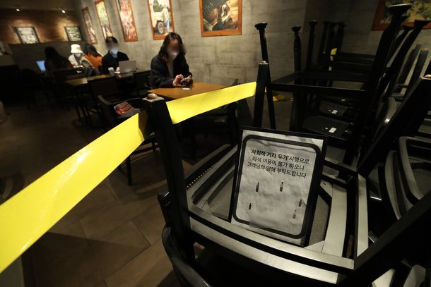 수도권 지역에 사회적 거리두기 2단계 격상을 하루 앞둔 23일 낮 서울 시내 한 프렌차이즈 카페에 탁자와 의자가 한 쪽에 쌓여있다. 백소아 기자