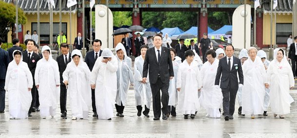 윤석열 대통령이 지난 18일 광주 국립5·18민주묘지에서 ‘오월의 어머니’들과 함께 5·18 민주화운동 43주년 기념식장에 입장하고 있다. 연합뉴스