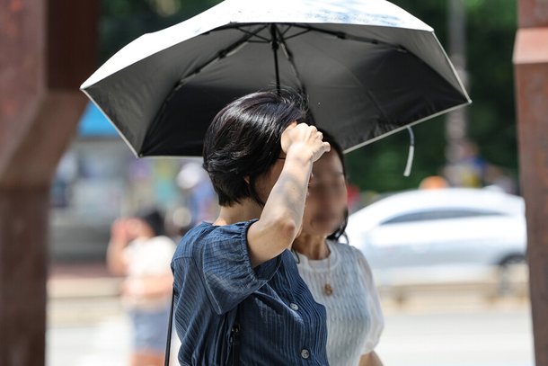 전국 곳곳 폭염주의보가 발효된 7월19일 오후 서울 종로구 마로니에 공원을 지나가는 시민이 손으로 햇볕을 가리고 있다.연합뉴스