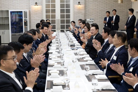 윤석열 대통령이 2일 서울 용산 대통령실 앞 파인그라스에서 열린 국민의힘 원내지도부 초청 만찬에서 추경호 원내대표 등 참석 의원들과 함께 박수치고 있다. 연합뉴스