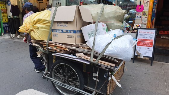 15일 김모(78)씨가 폐지가 가득 실린 손수레를 힘겹게 끌고 인사동길을 지나가고 있다. 윤상언 기자