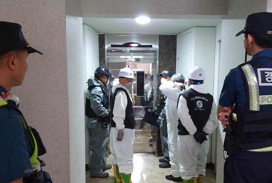지난 11일 새벽 화재가 발생한 충남 천안의 한 아파트 안 주방 냉장고 안에서 시신 2구가 발견됐다. 현장 조사를 위해 경찰 과학수사대를 비롯한 감식팀이 화재 현장으로 들어가고 있다. [연합뉴스]