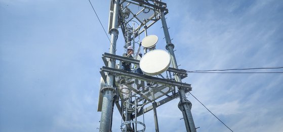 SKT 직원들이 도서 지역에 설치된 5G 마이크로웨이브 통신 장비를 점검하는 모습. 사진 SKT