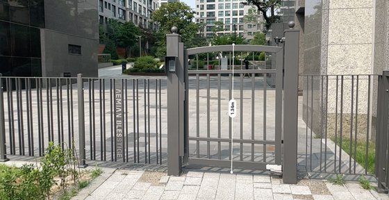 지난 20일 서울 강남구 개포동 래미안블레스티지 측면 출입구에 철제 담장이 설치돼있다. 해당 담장의 높이는 약 1.3m로, 2m를 넘지 않아 건축법 적용을 받지 않는다. 장서윤 기자
