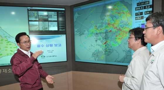2011년 7월 28일 이명박왼쪽 전 대통령이 서울 동작동 한강홍수통제소를 방문해 통제소 관계자들로부터 홍수 상황에 대한 보고를 받고 있다. 청와대사진기자단
