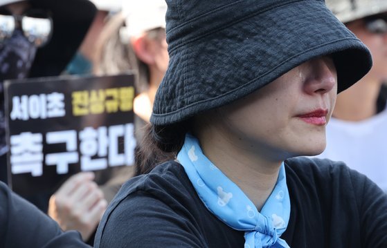 지난 5일 서울 광화문에서 열린 교사와 학생을 위한 교육권 확보를 위한 집회에서 한 교사가 사망한 서이초 교사 유가족의 발언을 들으며 눈물을 흘리고 있다. 연합뉴스