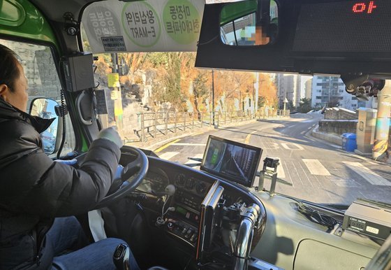 21일 오전 서울 성동구 큰매봉산 인근 구간을 지나는 성동02번 버스기사 유모61씨가 지난 1일 설치된 도로 열선을 가리키고 있다. 그는