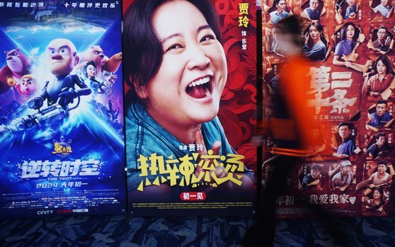 춘절 연휴 기간인 지난 16일 중국 항저우시에서 한 시민이 영화 포스터 앞을 지나고 있다. 신화통신=연합뉴스