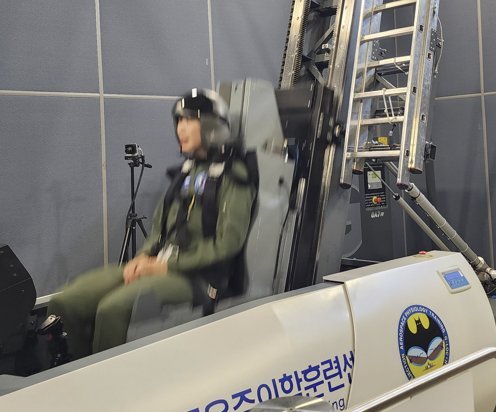 28일 공군 우주항공 의료센터에서 기자가 비상탈출 훈련을 받고 있는 모습. 레버를 당기면 로켓이 쏘아지듯 순식간에 상승한다.