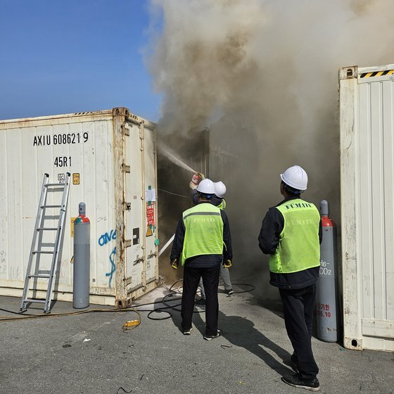 지난 4일 오전 경남 창원시 용원신항에서 방역 관계자들이 오렌지 컨테이너에서 발생한 화재를 진압하는 모습. 독자 제공