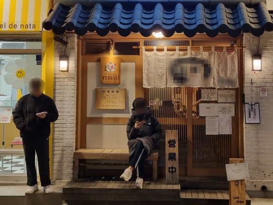 지난 21일 오후 7시 서울 서대문구의 한 무음 식당 앞에서 남성 두 명이 순서를 기다리고 있다. 박종서 기자