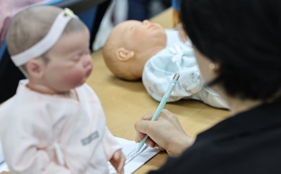 조부모들이 지난 9월 11일 서울 서대문구보건소에서 열린 우리손주 육아교실에서 아기 마사지 법을 배우며 메모하고 있다. 뉴스1