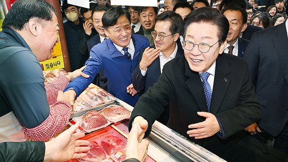 이재명 더불어민주당 대표가 지난해 11월 21일 오전 경기 수원시 팔달구 못골시장을 찾아 소상공인들과 인사를 나누고 있다. 뉴스1