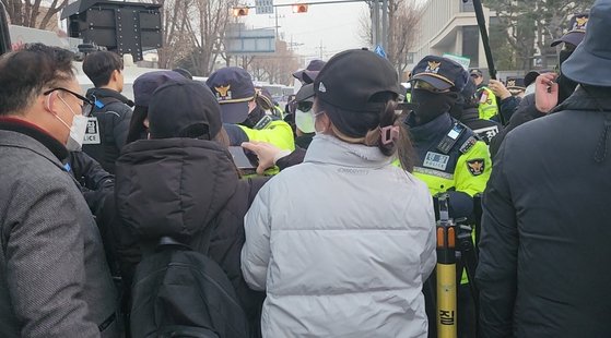 지난 1월 서울 종로구 헌법재판소 정문 앞에서 통행을 제지하려는 경찰을 향해 윤석열 대통령 지지자들이 휴대폰으로 얼굴을 찍으며 항의하고 있다. 김서원 기자