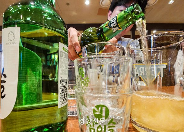 서울의 한 식당을 찾은 한 시민이 소주와 맥주를 섞어 마시는 소맥을 만들고 있다. 이준헌 기자