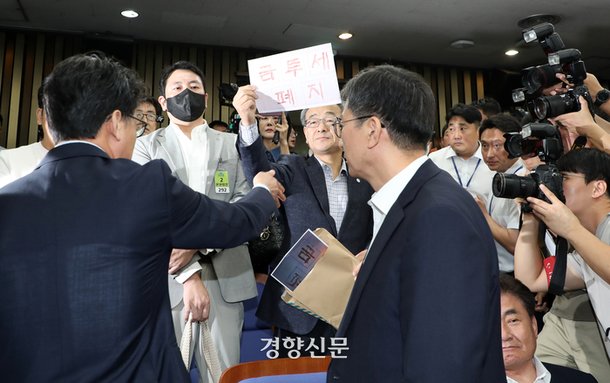 한국주식투자자연합 회원들이 24일 국회에서 열린 더불어민주당 정책 디베이트 ‘행복하고 정의로운 대한민국, 금융투자소득세 시행은 어떻게?’ 정책의총장에 들어와 ‘금투세폐지’ 가 적힌 종이를 들고 시위를 하고 있다. 박민규 선임기자