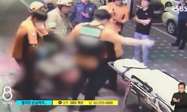 지난 1일 경기 군포시의 한 술집에서 흉기에 찔린 피해자가 구급대원들에 의해 이송되는 모습. SBS 보도화면 캡처