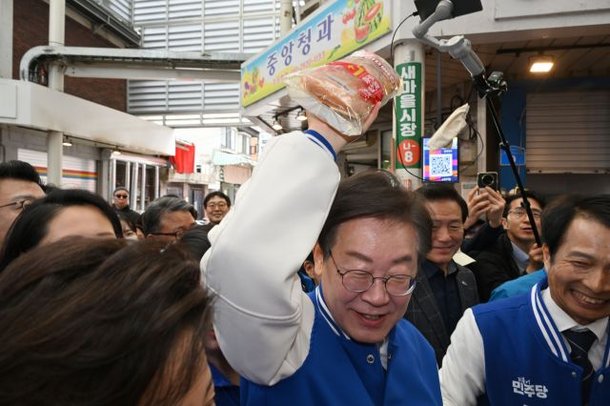 더불어민주당 이재명 대표가 24일 서울 송파구 잠실 새마을전통시장을 방문해 시민들로부터 빵을 전달받고 있다. 사진공동취재