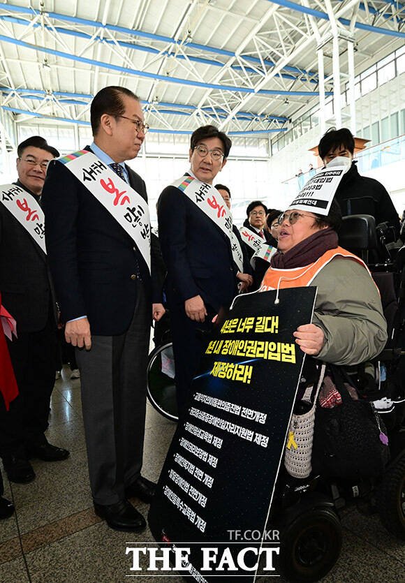 권영세 국민의힘 비상대책위원장왼쪽이 24일 오전 서울 용산구 서울역에서 설 귀성 인사를 하던 중 전국장애인차별철폐연대 회원의 면담 요청을 받고있다. /남윤호 기자