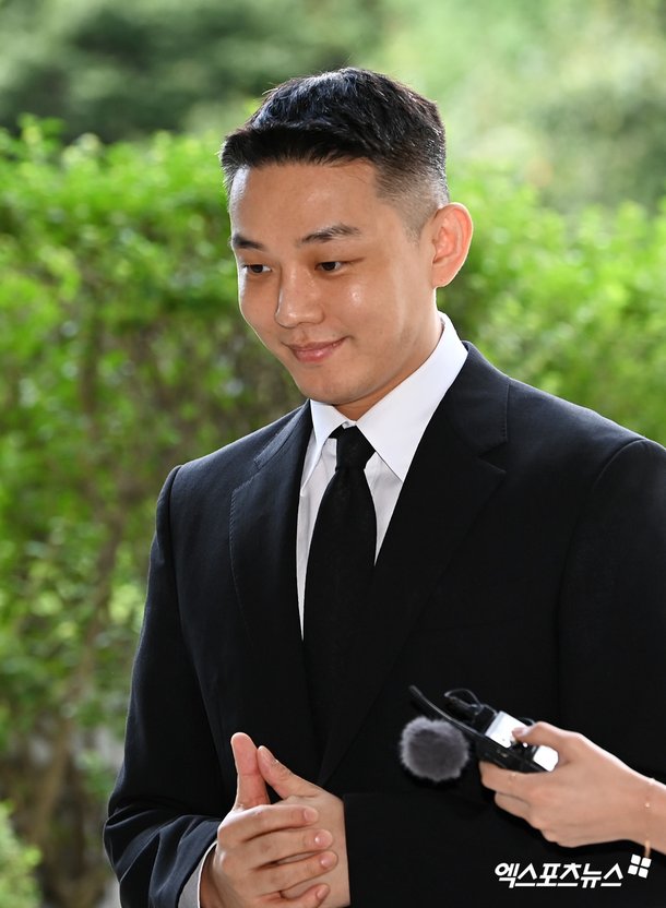 Yoo Ah-in smiling as he attends the first-instance trial' photo